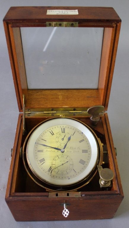 Marine Chronometer in Mahogany Case: Marine chronometer in locking mahogany case with beveled glass top by Kelvin & Wilfrid O. White Company, Boston, MA. Roman numeral brass face with second hand, "Made in England". Set in gyroscope hold