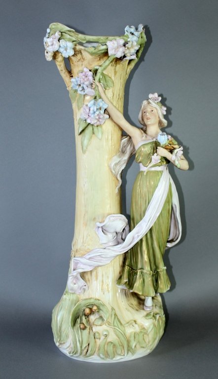 Royal Dux Art Nouveau Figural Vase: Royal Dux Art Nouveau figural vase, 26" high, fair maiden holding bouquet next to organic form tree trunk, beautiful pastel colors, minor floral chips and minor chip to rim, pink triangle wafer mark, 