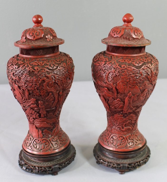 Pair of Early Carved Cinnabar Covered Jars: Pair of early carved cinnabar covered jars on ornate bases, each 11" tall relief carved with plants, mountains, figures, late 19th century, marked "China", very good condition.