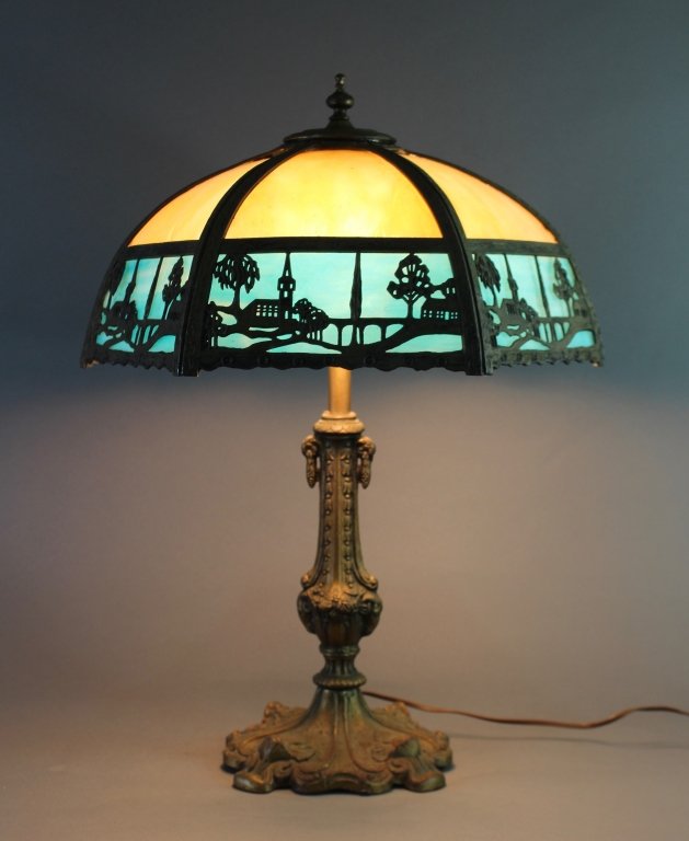Slag Panel Overlay Table Lamp: Slag panel scenic overlay table lamp c. 1915, unsigned but probably Miller, caramel and sky blue panels, 2 socket (one replaced), intact and good condition. 24" high, 17" diameter.