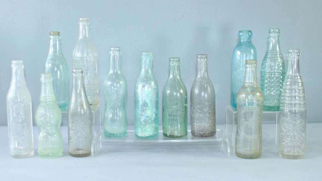 Collection of 13 Early Soda Bottles: Collection of 13 early soda bottles: Coca-Cola Bay Bottling Co. (lip chip), St. Andrews, Fl, Coca-Cola Waycross, GA, Coca-Cola, Macon, GA. Pepsi Cola pat no. 808587, Dr. Pepper, Nu-Grape pt. 5/9/1920,
