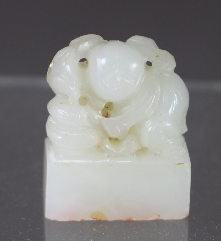 Chinese White Jade Ink Stamp: Chinese white jade ink stamp, figure of humped over baby at covered basket, remnants of red ink in Chinese calligraphy stamp, 1.25" x 1" x .5", good condition.