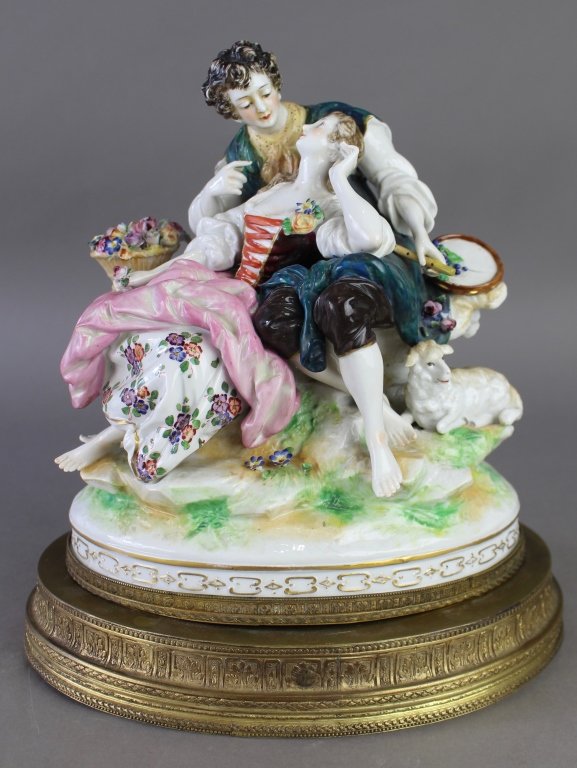 Ludwigsburg Porcelain Figural Grouping: Ludwigsburg porcelain figural grouping on bronze plinth. Man, woman and lamb resting, man with tambourine and flute, she with floral basket, signed, good condition, 12" x 10" 7". Artist signed "LaTour