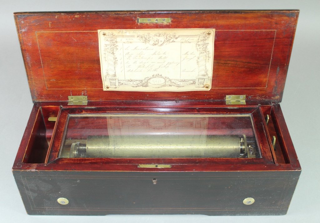 Swiss Music Box Cylinder Player: Swiss music box, brass cylinder playing 6 airs, inlaid rosewood cabinet, no missing teeth, very good condition and sound, 18.5" x 5.5" x 7".