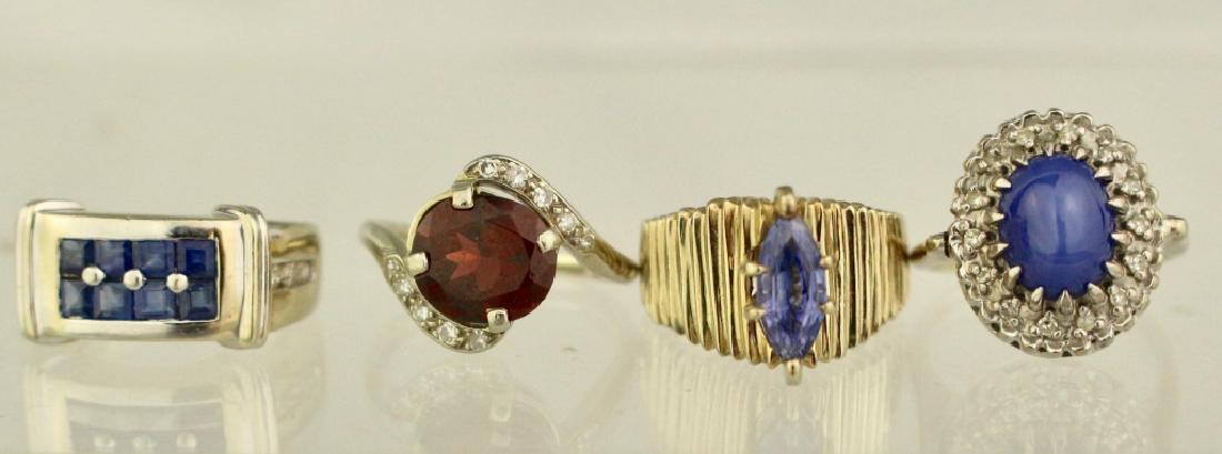 Group of Four Lady's 14K Rings: Group of four lady's 14K white gold fashion rings: star sapphire encircled with diamonds, marquis cut sapphire solitaire, inset baguette cut sapphires with round cut diamond on each side, garnet cente