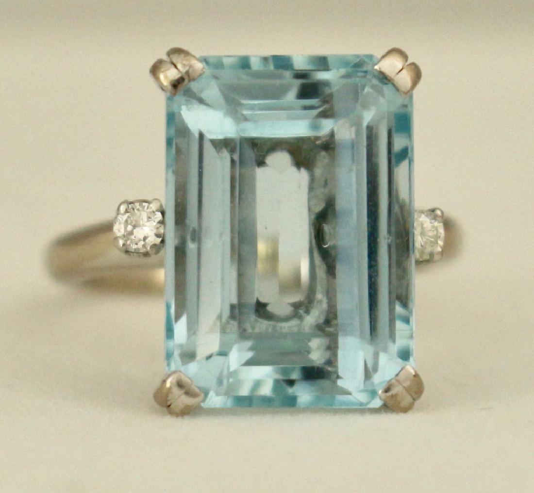 Lady's 18K White Gold and Aquamarine Ring: Lady's 18K white gold and emerald cut aquamarine ring, approximately 12 carats. Two .05 diamonds on each side, size 3.5. Ring mounting with stones 5.5 grams, a real beauty. A tiny chip on lower right 