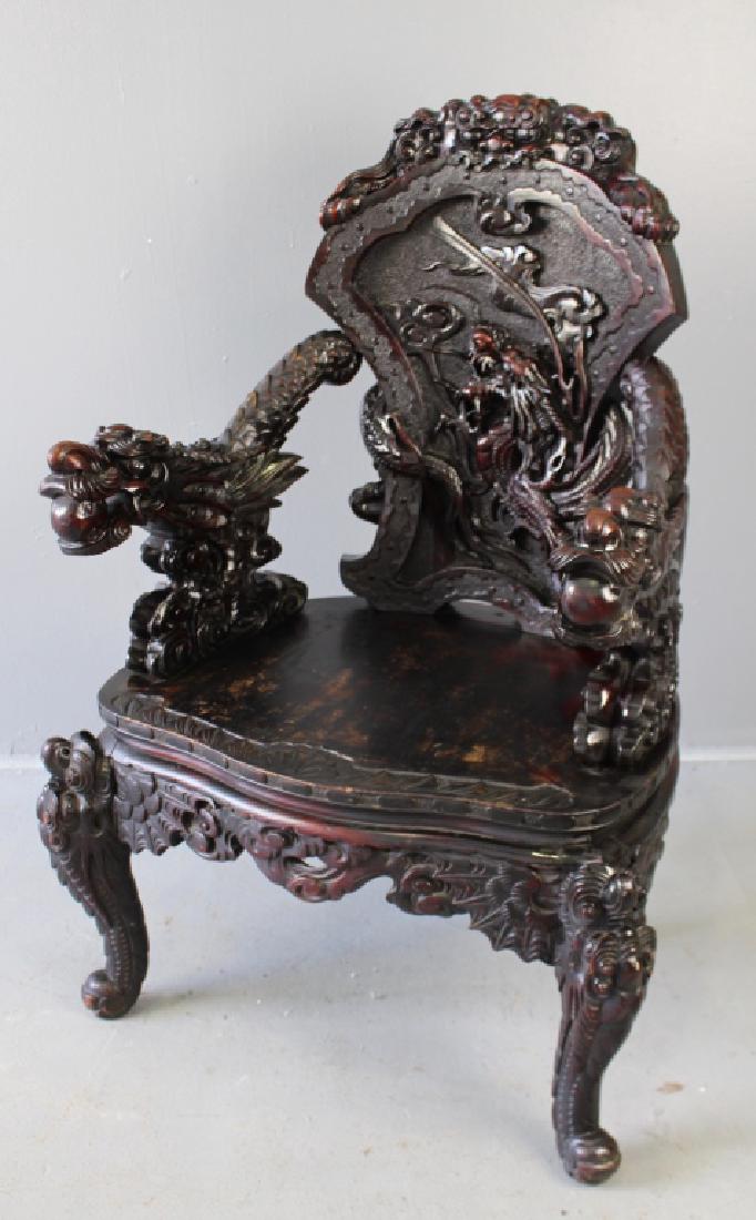 Chinese Carved Dragon Arm Chair: Chinese carved dragon arm chair, elaborate carving on back, dragon arms with balls in teeth, carved backside, apron and legs, minor loss to finish in seat, 41" x 28" x 23"d.