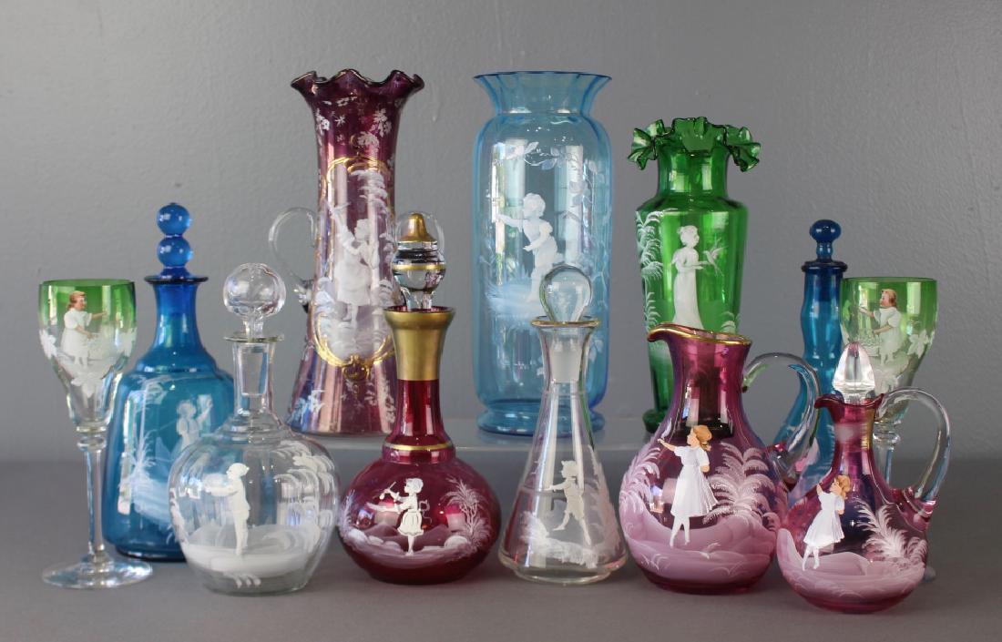 Collection of Mary Gregory Enamel Glass: A collection of 12 pieces of Mary Gregory enamel decorated glass. Children on blue, green, clear and cranberry glass, cruets, vases, goblets, pitcher, among others, all in good condition.