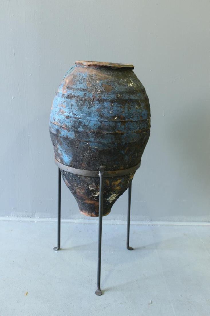 Mediterranean Terra Cotta Oil Jar: Mediterranean terra cotta oil jar, c. 200 BC-100 AD on wrought iron stand, jar is 31" x 17" diameter, 41" on stand, some chips but no crack or breaks.