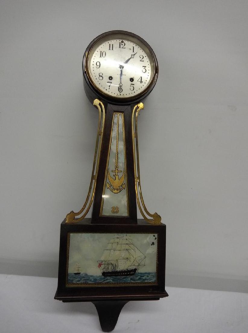 Seth Thomas Banjo Clock: Keywind. Reverse painted on glass american ship scene, some flaking. Missing finneal from top. 25" tall, 9" wide, 4" deep.