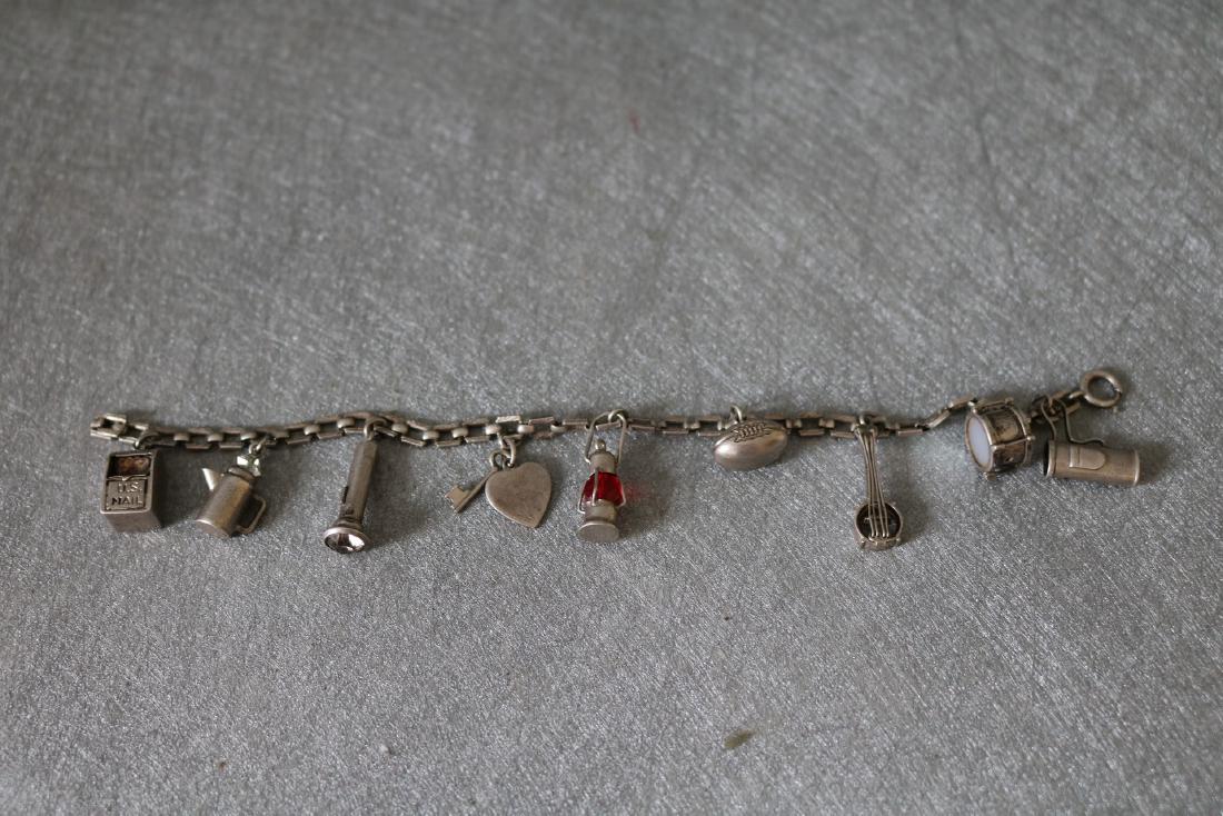 Vintage Sterling Silver Charm Bracelet: 9 charms including mail box, Tea pot, flash light, heart with key, lantern, foot ball, banjo, drum, and golf bag