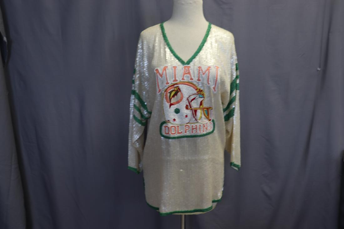 Miami Dolphins Beaded and Sequined Tunic: Sheer woven tunic covered with opalescent sequins, seed bead Miami Dolphins detail in front, colored seed beads on sleeves, hem, neckline. It measures approx. 40" at chest, 28" long, 21" across should