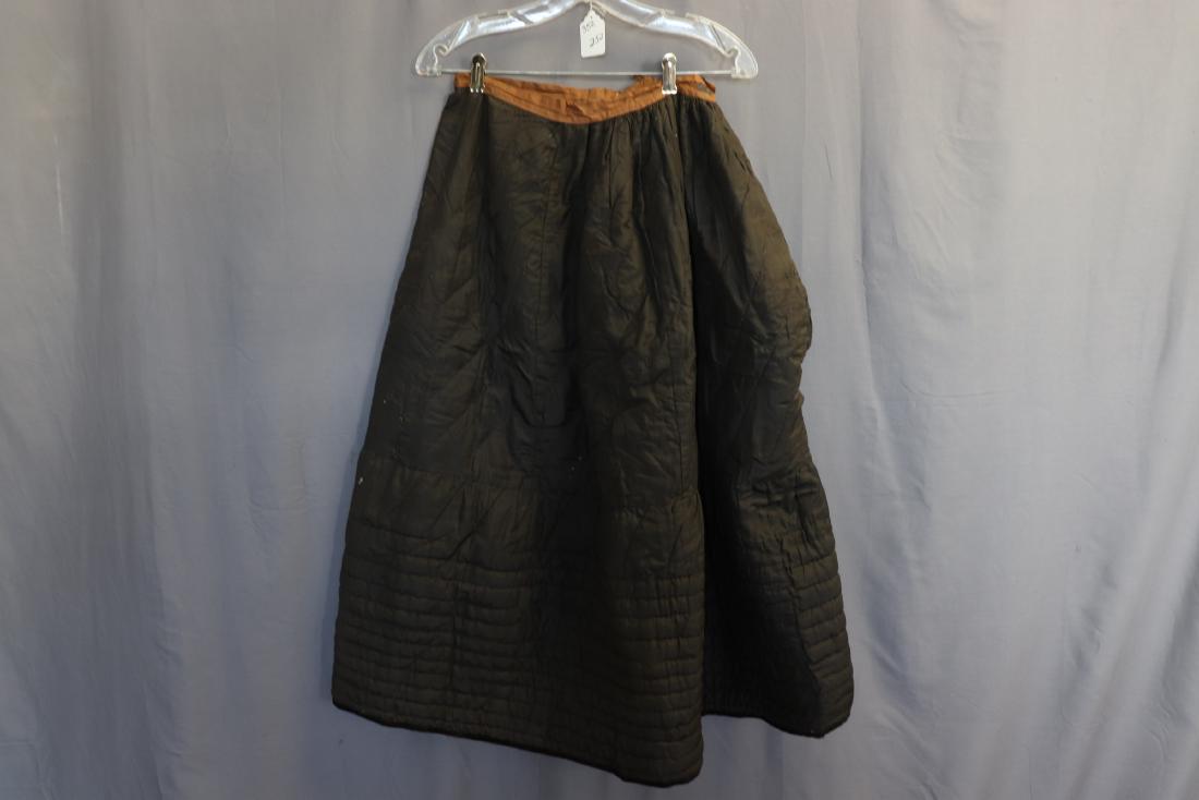 Victorian Hand Quilted Black Petticoat: Black silk outer, cotton batting, mixed fabric brown lining, waistband a bit tattered, a few small holes in the black silk, measures approx. 25" at waist, 35" long, a seam repair needed at side openin