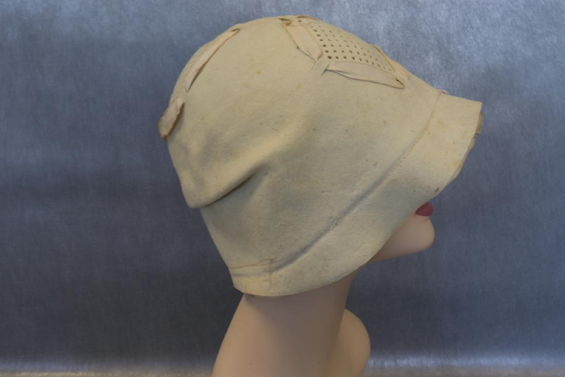 Antique 1920's Tony Finish Cloche Style Hat: Cream colored ribbon and punched wool detail, measures approx. 22" around inside brim, silk lining (needs to be tacked down with a few stitches), very light soil, a few marks in the wool-see photos.