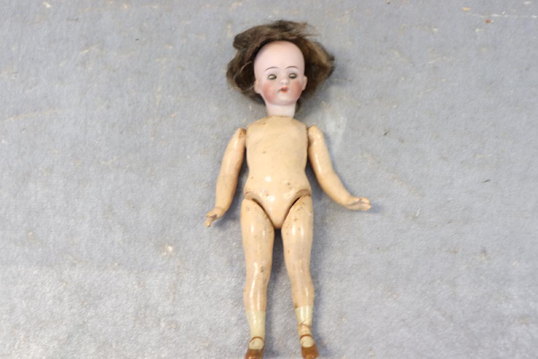 Antique Bisque Head Doll With Composition Body: She measures 7" long, looks to have original wig. Light soil, broken finger