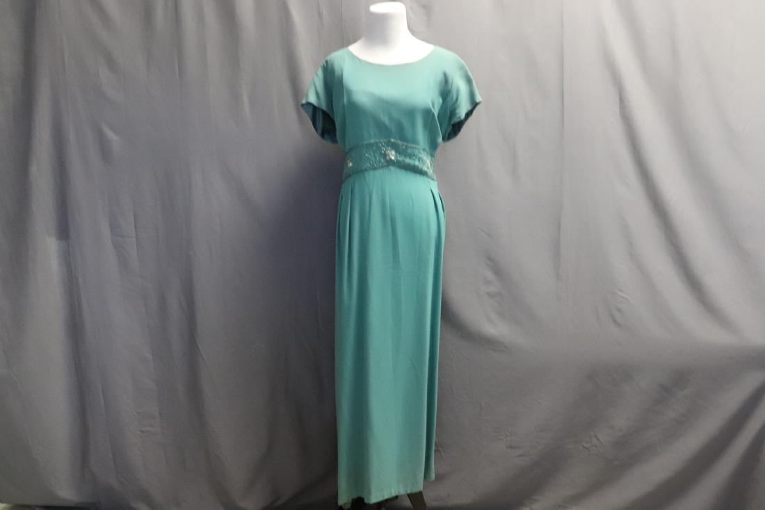 1960's Green Crepe Evening Dress with Beading: Glass beading around waist, sequins added on front, zipper in back (recently added), pleats in back, fully lined. Measures approx. 42 at bust, 40 waist, 55 long. Zipper needs to be sewn into place (it