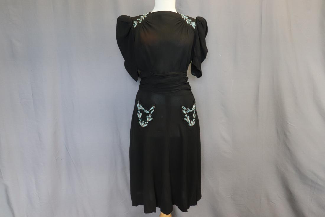 1940's Classic Black Dress with Beading: high square neck, short pouf sleeves, high waist with smocking under bust, attached wide band at waist, 2 sweet front pockets with beading, back eye hook and side zipper, under arm staining and seam r