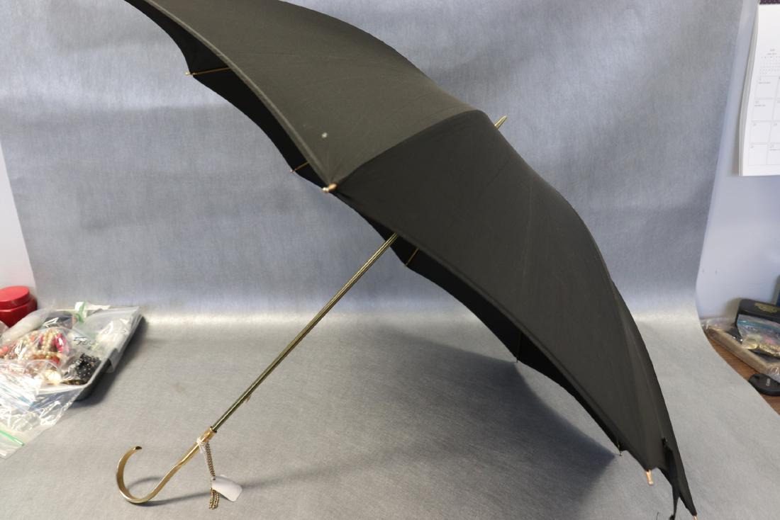 Old Store Stock Black & Gold Lord & Taylor Umbrella: Large size umbrella with gold tone handle and frame, Nylon fabric. Original label for Lord & Taylor on inside. Made in Italy. The name Florence embossed in the nylon fabric. Opened up measures approx.