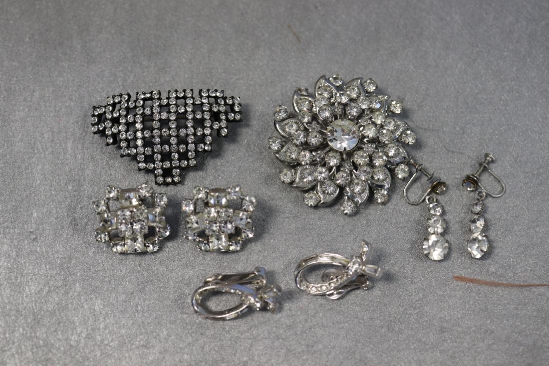 Lot of Vintage Rhinestone Earrings, Brooches: Two brooch pins, approx. 2" wide, one clip-on earring set, two screw-back earrings. The larger screw back earrings are marked sterling.