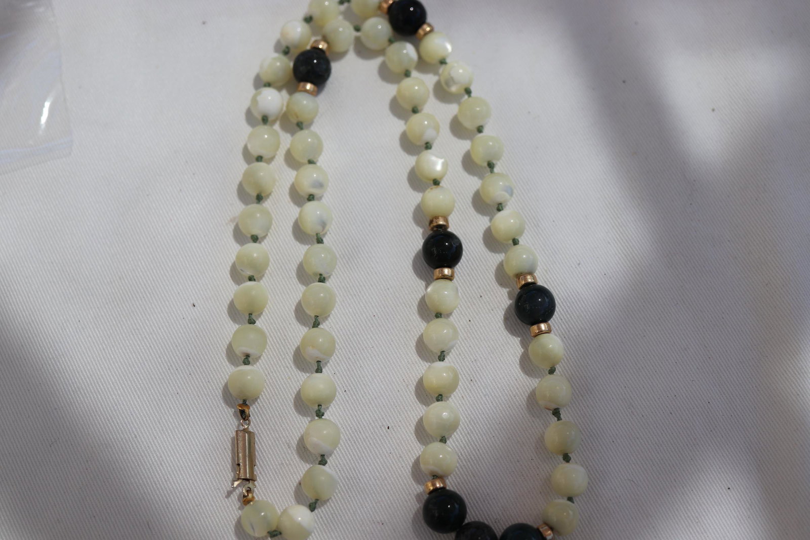 Vintage Hand Knotted White and Green Jade Necklace: With Gold tone spacers, approx. 25" long.