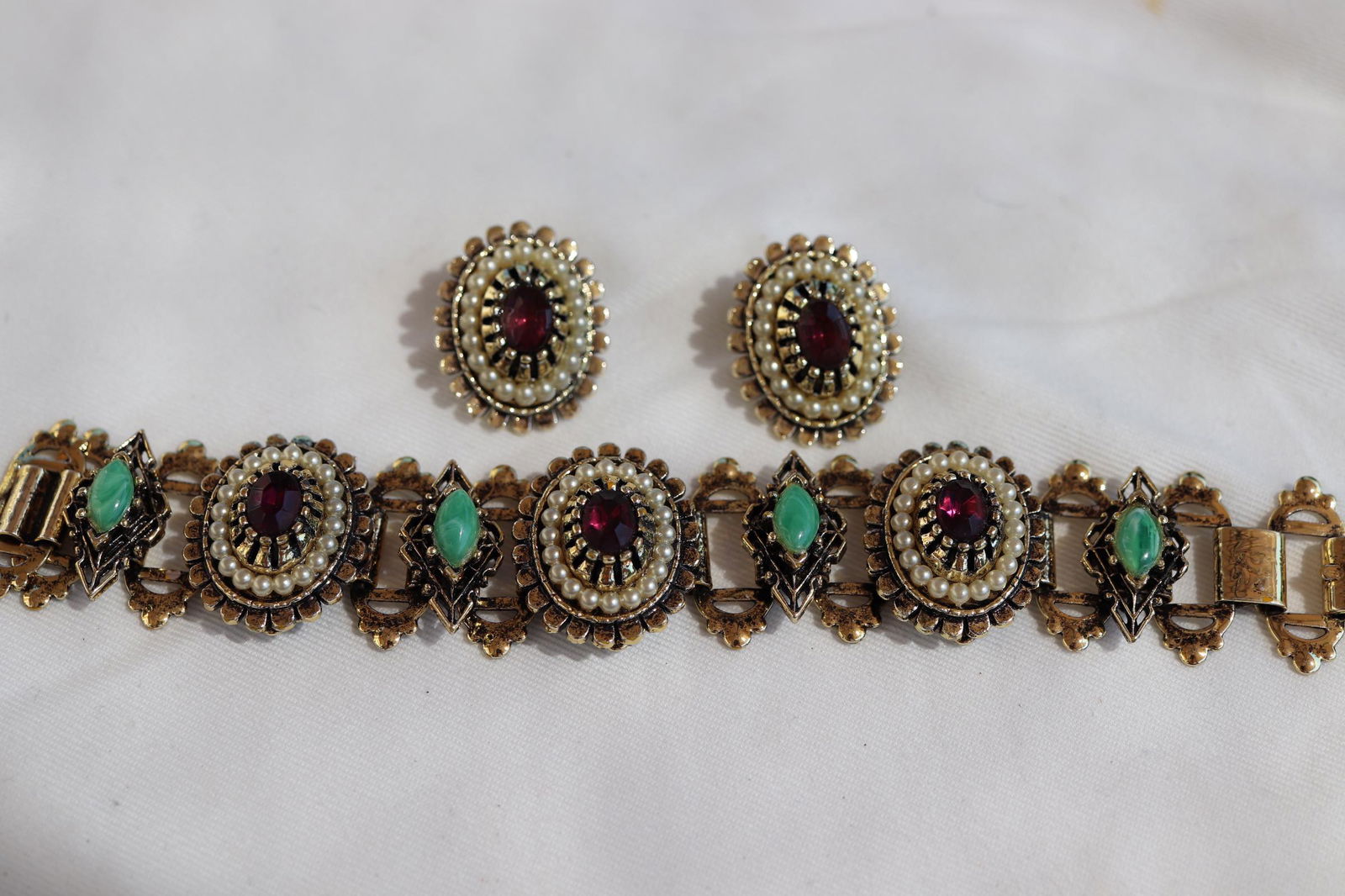 Vintage Bracelet & Earring Set, Circa 1960: Purple oval stones set in gold tone frame with tiny pearl beads, and jadeite marque stones, bracelet approx. 7 inches, clip on earrings approx. 1 inch