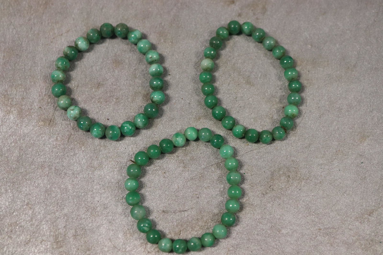 Vintage Lot of 3 Green Jade Bracelets: On elastic cord, approx. 3" across