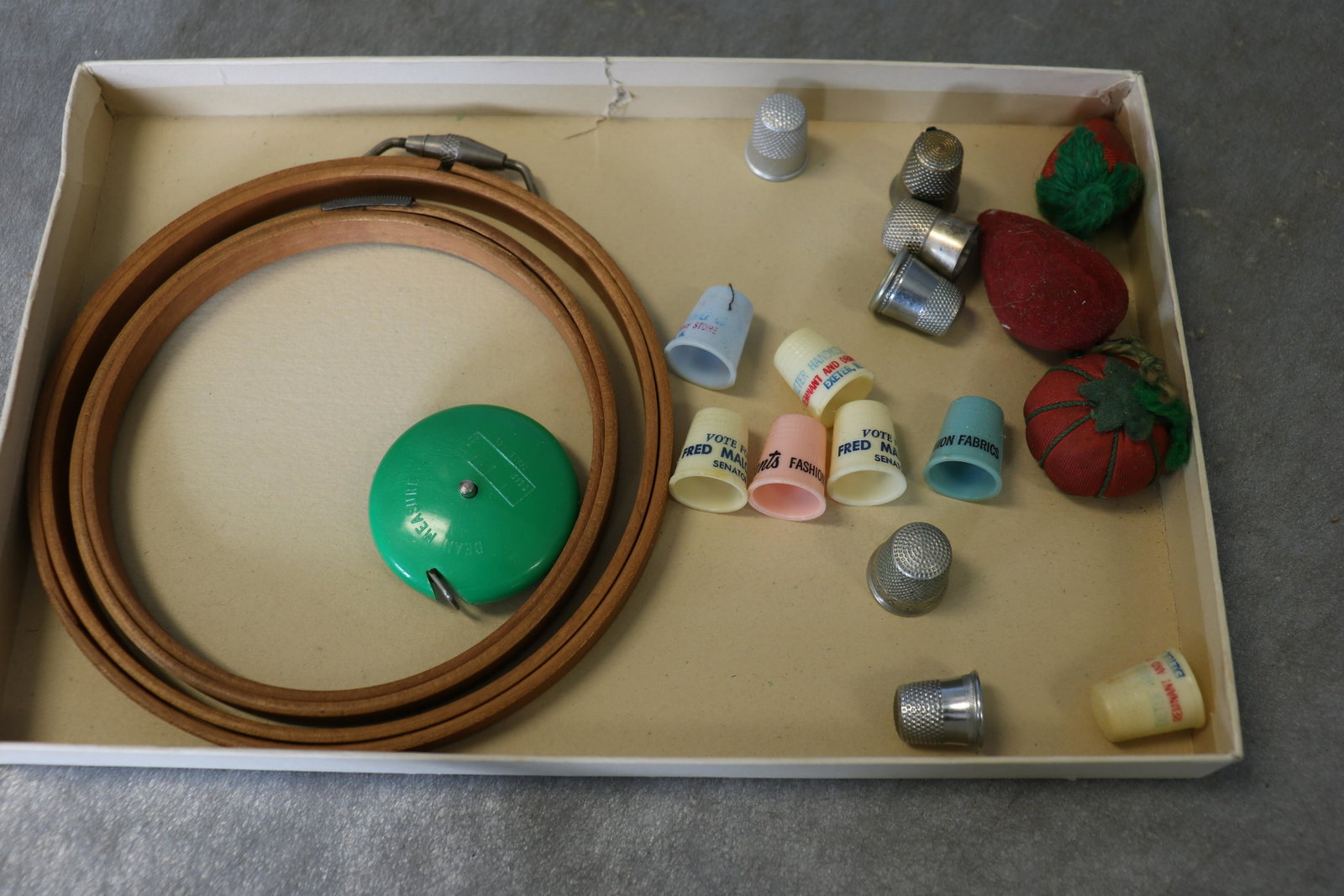 Lot Vintage Thimbles, Emery Strawberries, Wooden Hoops: Green retractable tape measure from England, Advertising thimbles (one monogrammed MBL), emery pincushion strawberries-some wear, 2 wooden embroidery hoops