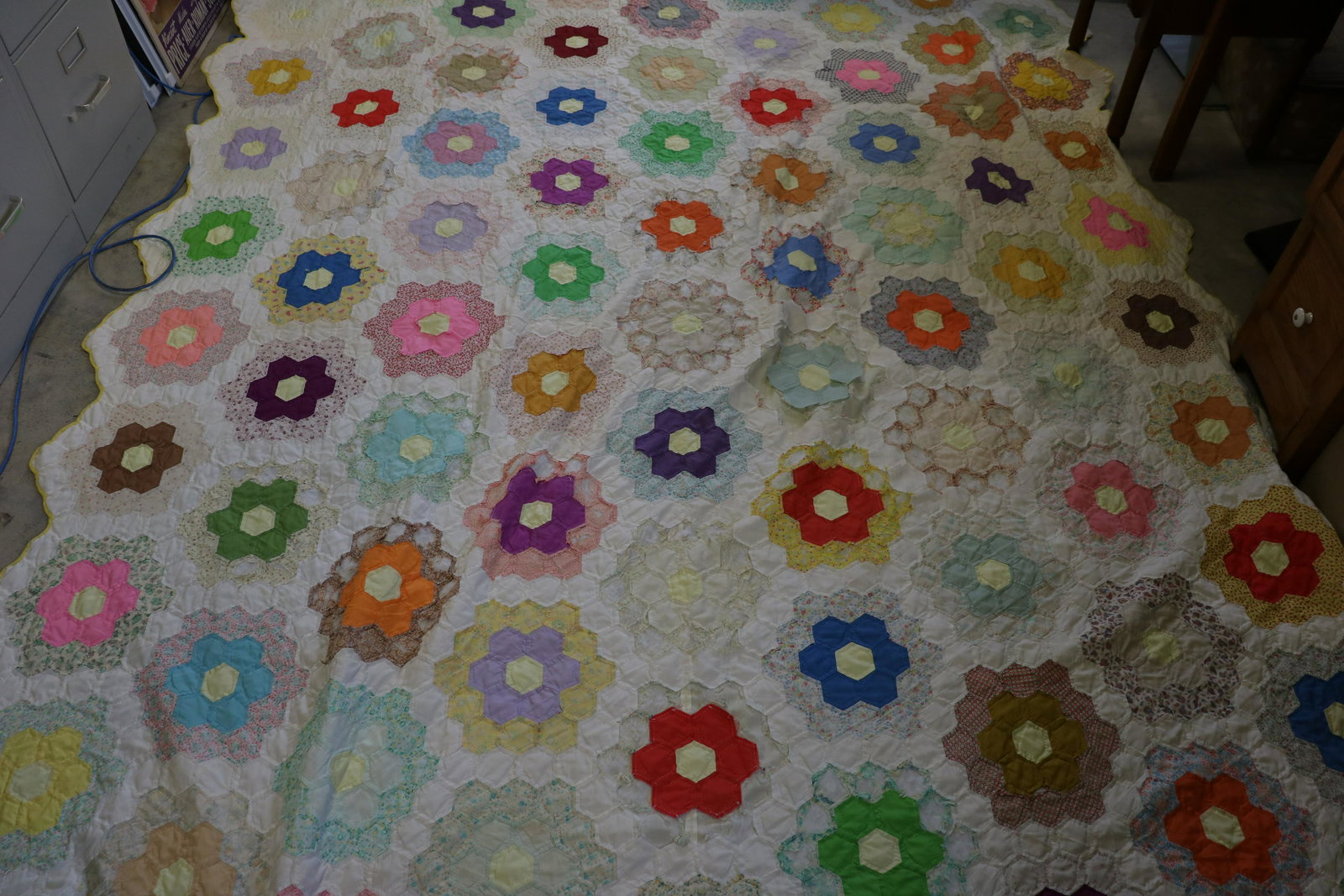 Vintage Grandmother's Flower Garden Quilt: Approx. 104x88", many worn and missing flower pieces, batting appears to be polyester as well as many fabric pieces. Pale yellow backing in good condition.