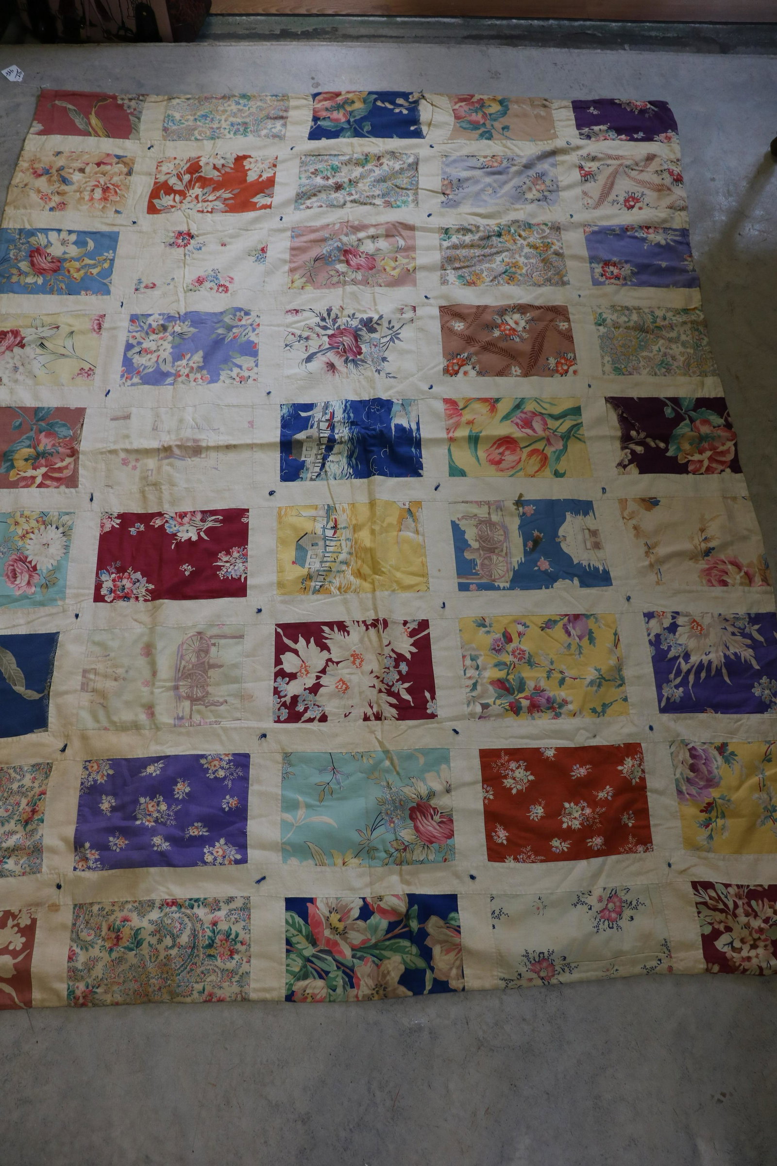 Vintage Stamp Stacker Patchwork Quilt: Hand tied, circa 1930's printed fabric, 7x10" blocks with muslin lattice between each block, some novelty prints, plain center back with plaid fabric on wide edge. Approx. 75x56". Some seam repair nee