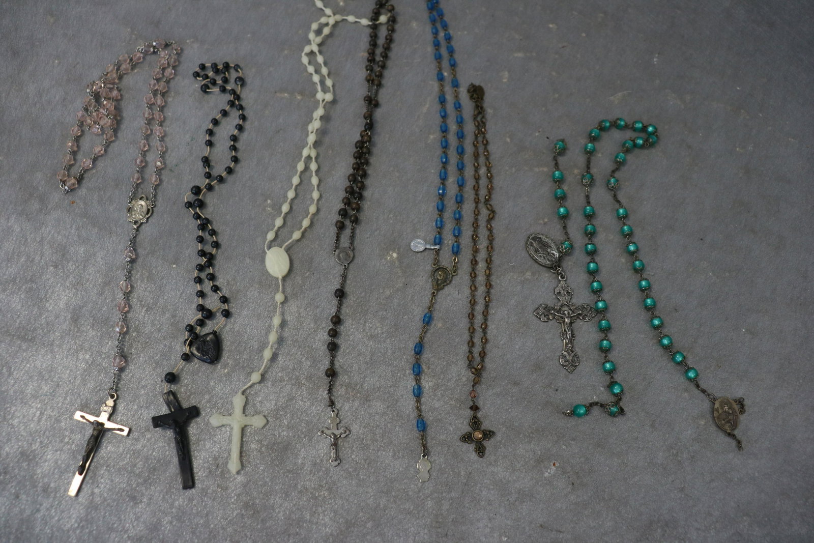 Lot of 8 Vintage Rosary Beads, Some Sterling: Iridescent green beaded marked sterling, large cross marked sterling, small cross with brown beads marked France. Blue beaded rosary marked Italy. The black set has a break in the cross.