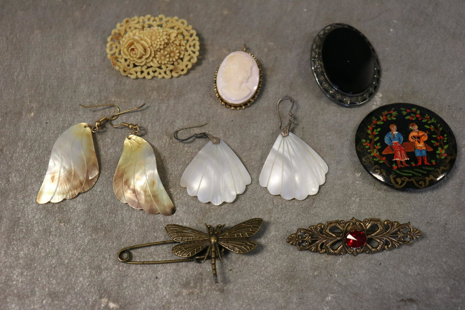 Lot Antique Brooch Pins, Vintage Earrings: 2-Pair carved mother of pearl shell earrings, pierced. Cameo brooch, early carved floral brooch, round hand painted brooch, dragonfly pin, black stone with marcasite detail. Gold tone brooch with ruby
