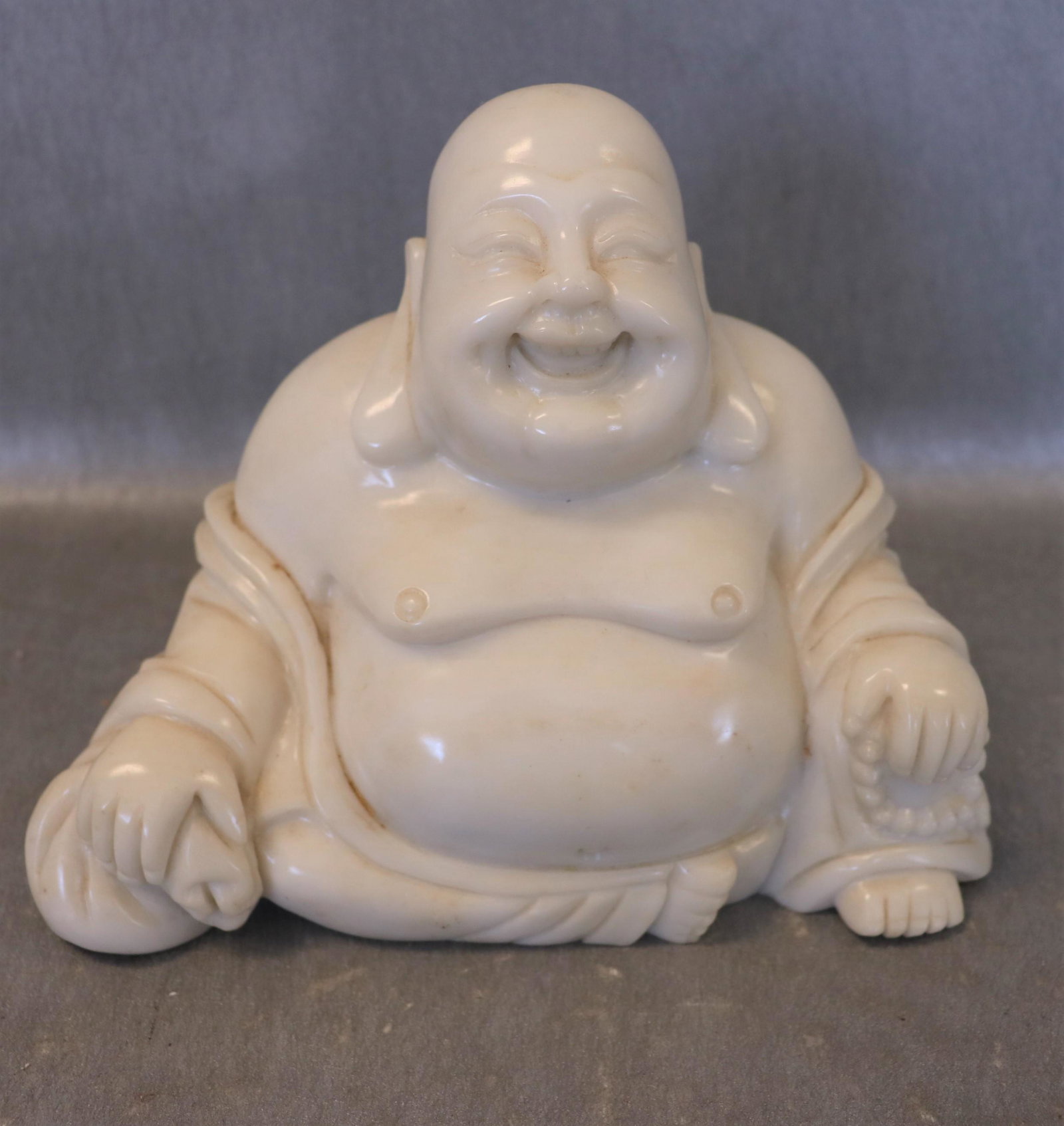 Carved Alabaster Laughing Buddha: great detail, open mouth with teeth showing, approx. 7 inches tall, 8 1/2 inches wide