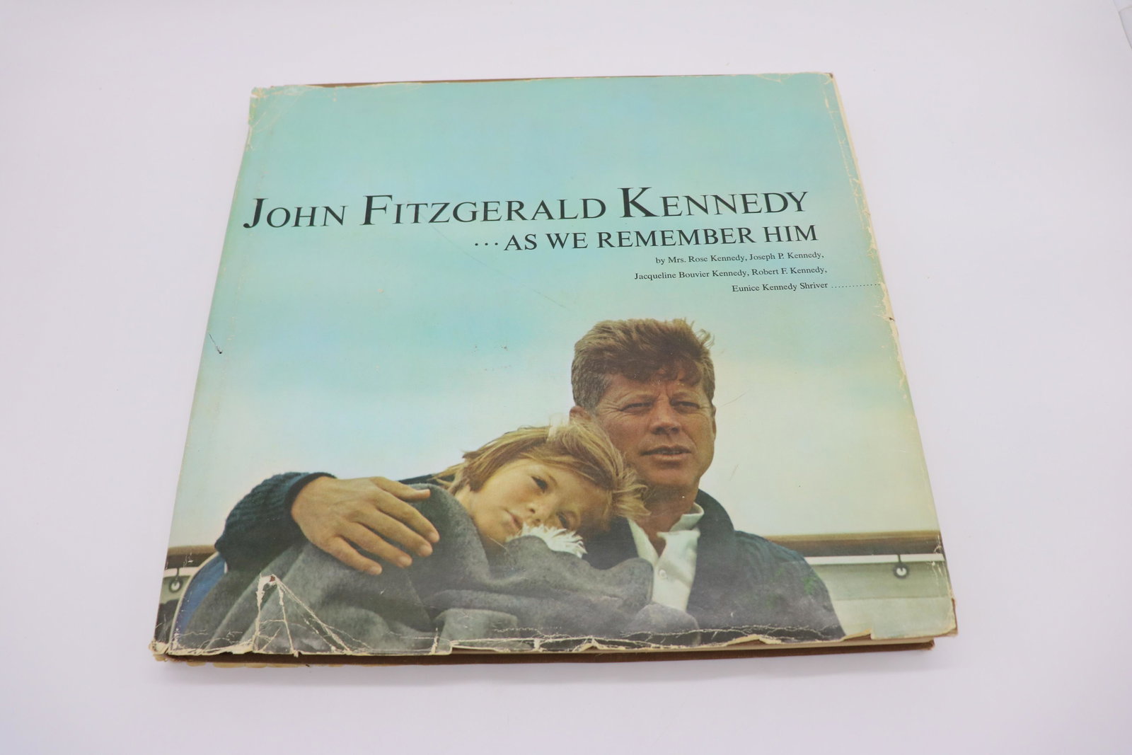 John Fitzgerald Kennedy, AS We Remember Him, 1965: Written by the people who knew him best: Mrs. Rose Kennedy, Joe P Kennedy, Jacqueline Kennedy, Robert Kennedy, Eunice Kennedy Shriver. Paper cover a bit tattered around edges, 13x13x1".