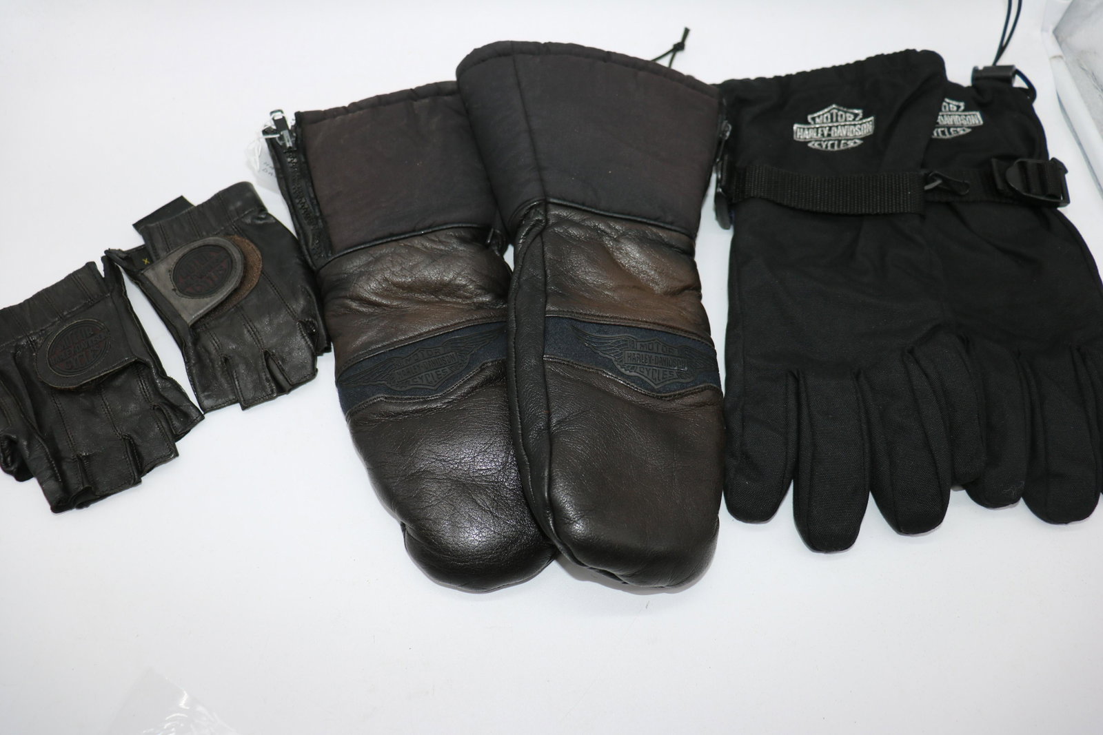 Lot Of 3 Harley Davidson Gloves, Mittens: Dark brown mittens, zipper at side, size small (men's), leather & nylon, light wear. Gloves, size small (men's) drawstring at wrist, reinforced palms, seam repair needed on one thumb. Leather fingerle