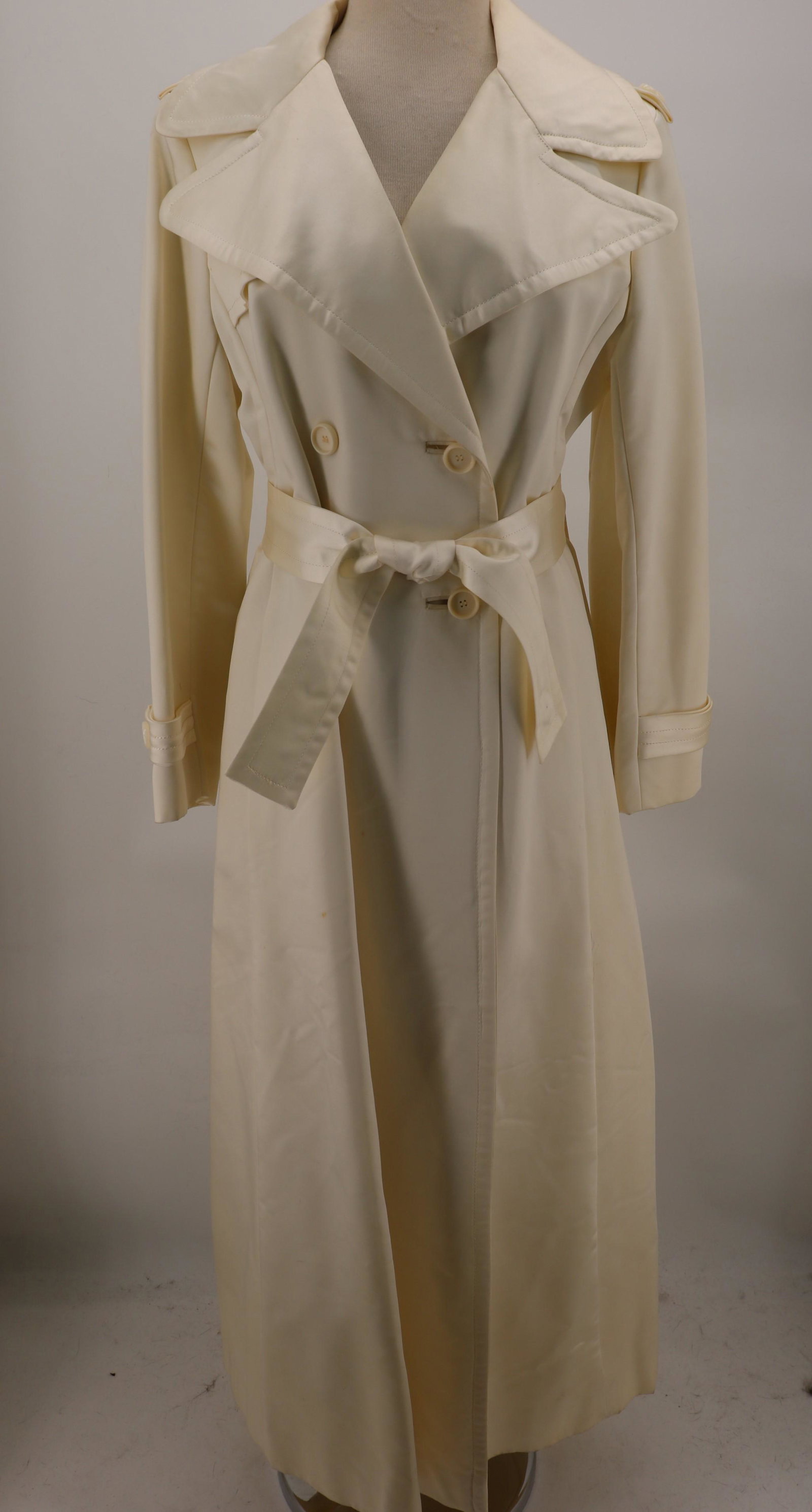 1960-70's Cream Satin Maxi Coat: Princess seams, 2 slit pockets, convertible collar, self belt, double breasted, trench style back, approx. 38 bust, 36 waist. Some light soil.