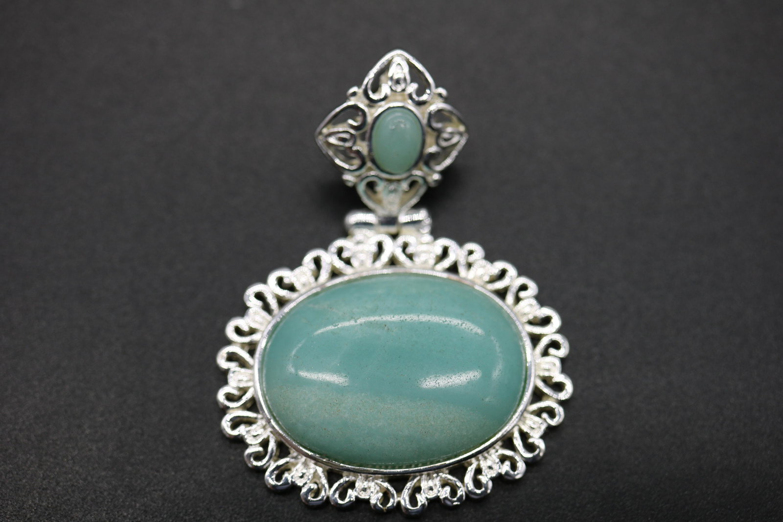 Vintage Sterling Pendant with Light Green Aventurine: marked 925 sterling frame with light green aventurine type stone, approx. 1 1/2 inches across, 2 inches tall