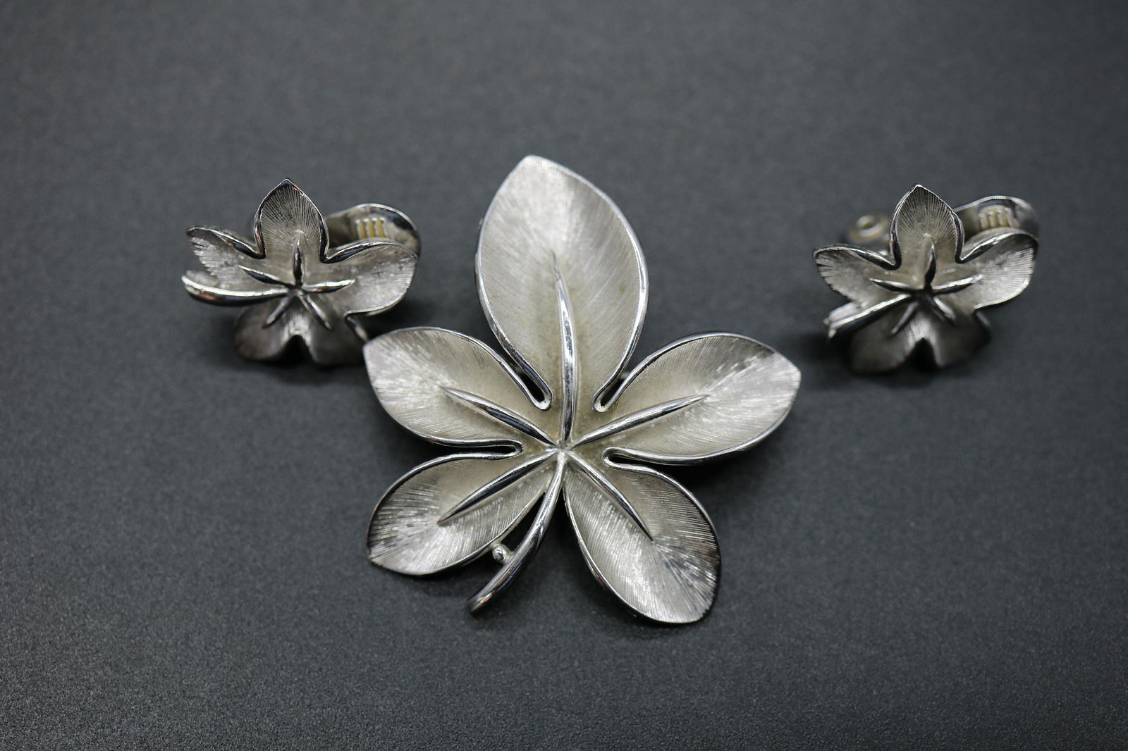 Vintage Monet Silver Tone Leaf Brooch & Earring Set: silver tone leaf brooch approx. 1 3/4 inches with matching clip on earrings