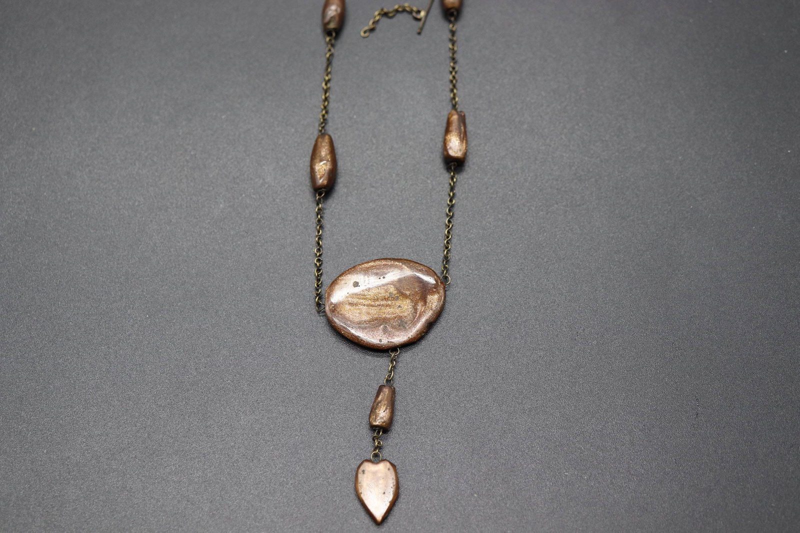 Antique Gold Stone Necklace: gold tone chain with gols stone beads, large center gold stone with hanging tassel with heart shaped gold stone, approx. 16 inch chain and 2 3/4 inch center stone & tassel