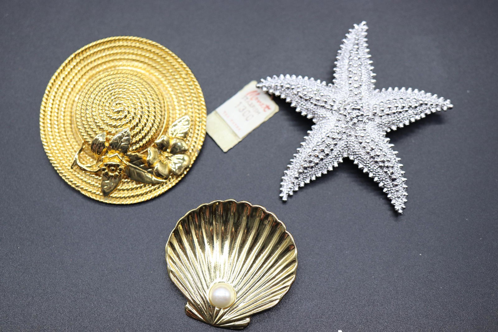 Lot of 3 Beach Style Brooches: silver tone Monet Starfish, gold tone beach hat, and gold tone Trifari Seashell with Pearl bead