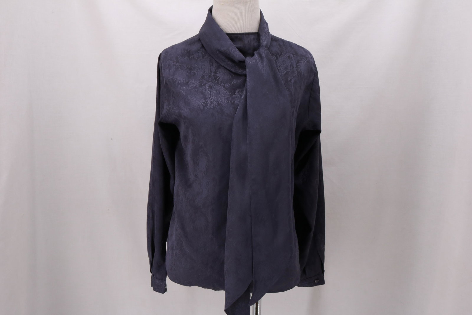 Vintage Deep Purple Jacquard Blouse with optional Pussy: Vintage Deep Purple Jacquard Blouse with optional Pussy Bow in polyester. Random catches along the bottom of the blouse. Tie is 69" long and 9" wide at the widest point. Buttons in the back. Approxima