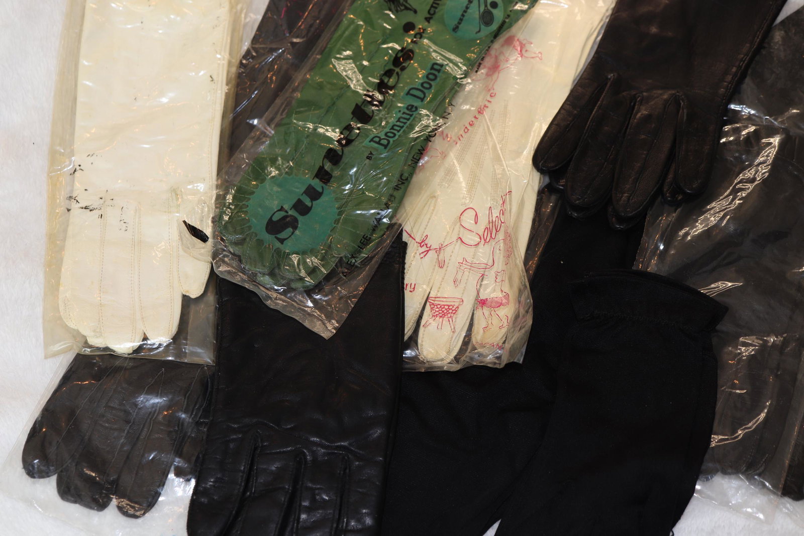 Lot of 10 Pair Vintage Ladies Gloves: one pair long black knit Rayon fingerless gloves, one other pair wrist length black Rayon by Van Raalte, 2 pair white leather kid skin one with silk lining, one pair green leather, 5 pair black leathe