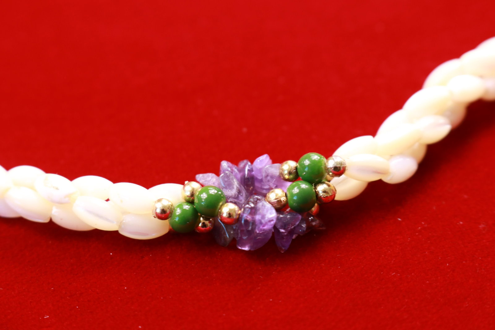 Natural Stone and Mother of Pearl Bead Necklace: White mother of pearl (MOP) beads braided and accented with clusters of amethyst and painted green beads. Measures about 22" long.
