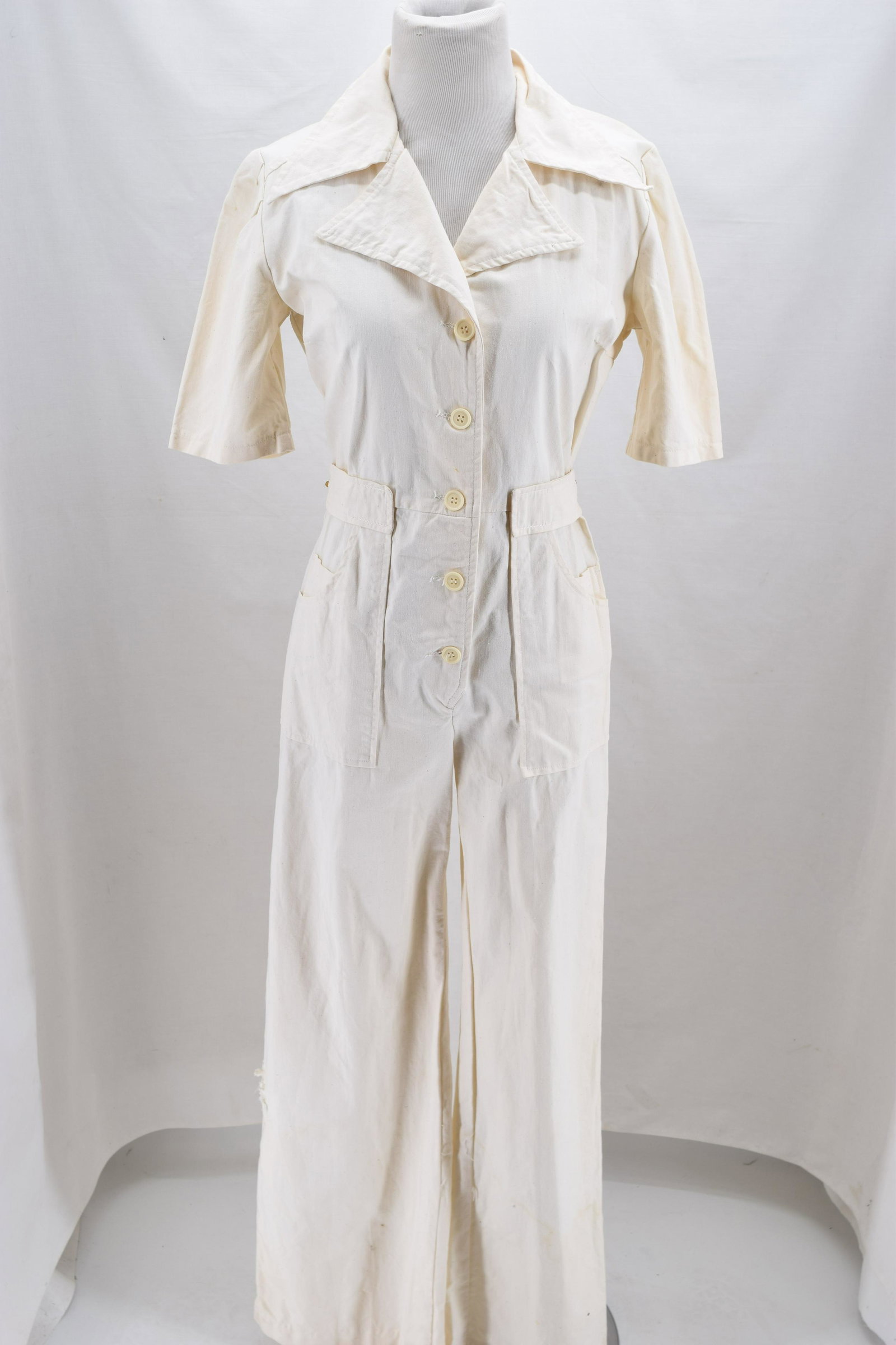 Vintage 1970's Cotton One Piece Jump Suit: short sleeve, button front, belt back with gold detail, large applied pockets, boot cut, destress leg, see photo's, approx. 38 bust, 26/28 waist, inseam 28