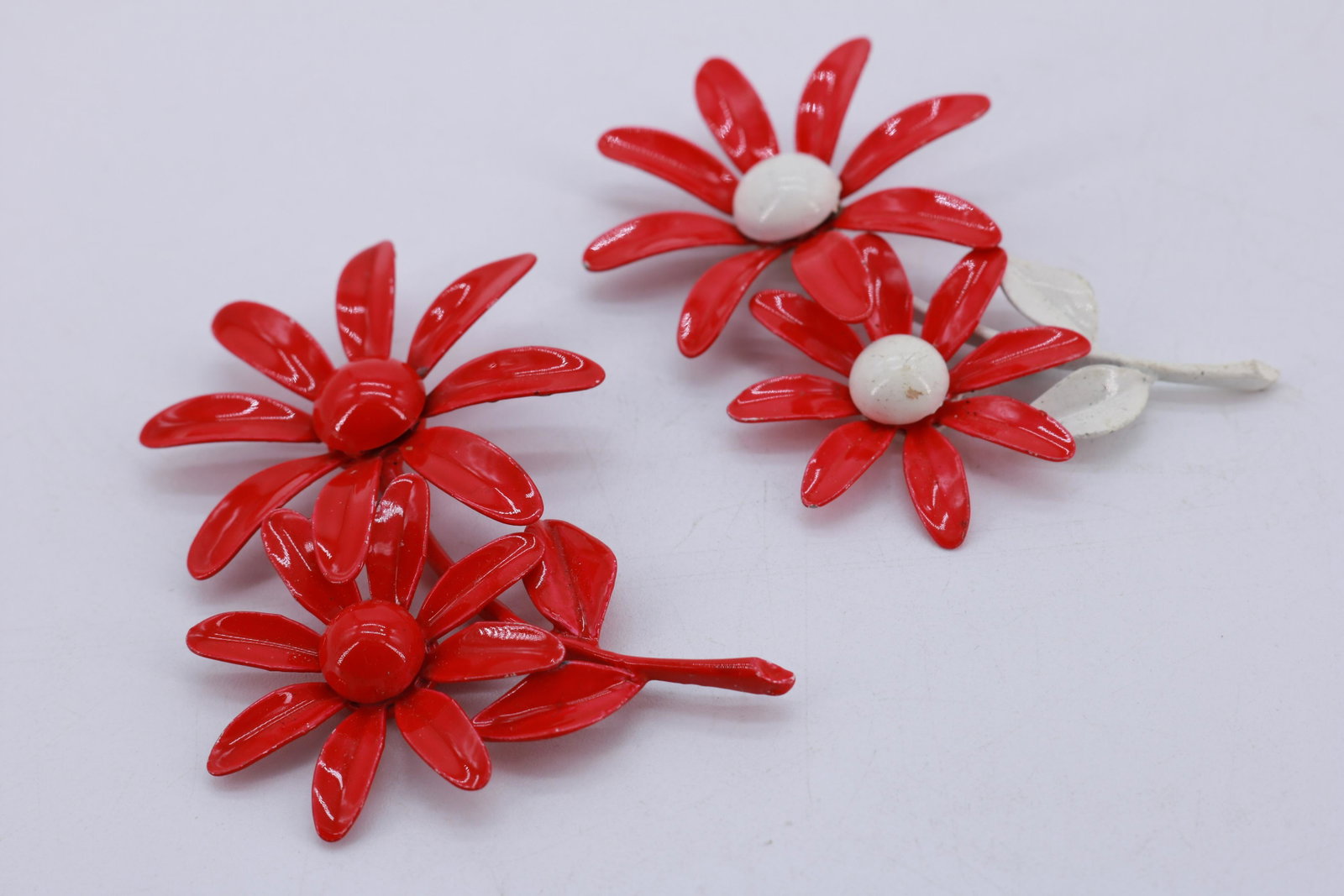Vintage 1960's Red & White Daisy Enamel Brooches: one solid red, the other red and white, approx. 3 1/4 inches, botth missing the pins