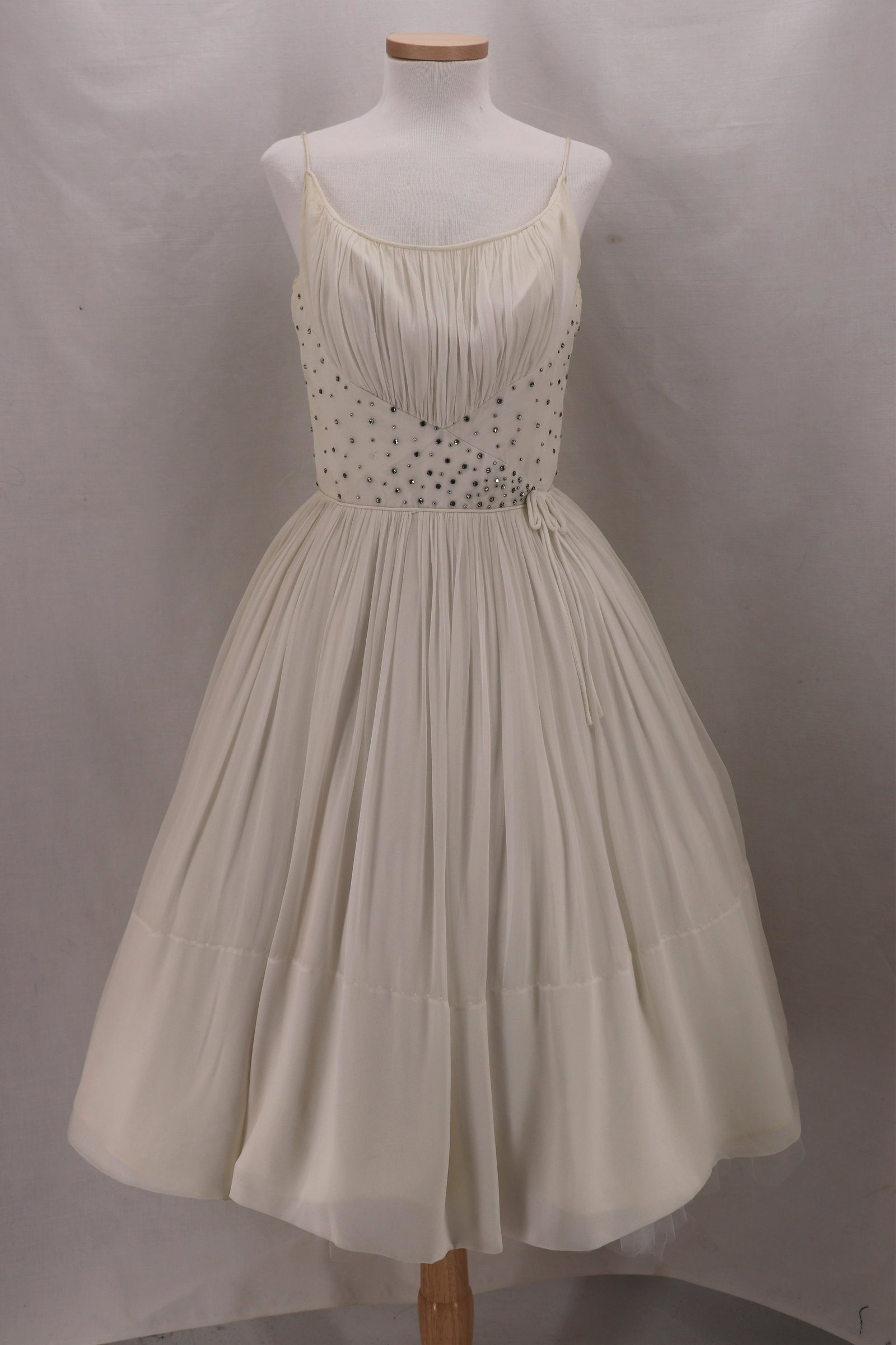 Vintage 1950's Chiffon Spaghetti Strap Pouf Dress: Spaghetti Straps, scoop neck, gathered bodice with rhinestones, piping at waist with small bow, full gathered skirt, back metal zipper, bust 32, waist 24, one missing rhinestone, small pin hole on hem