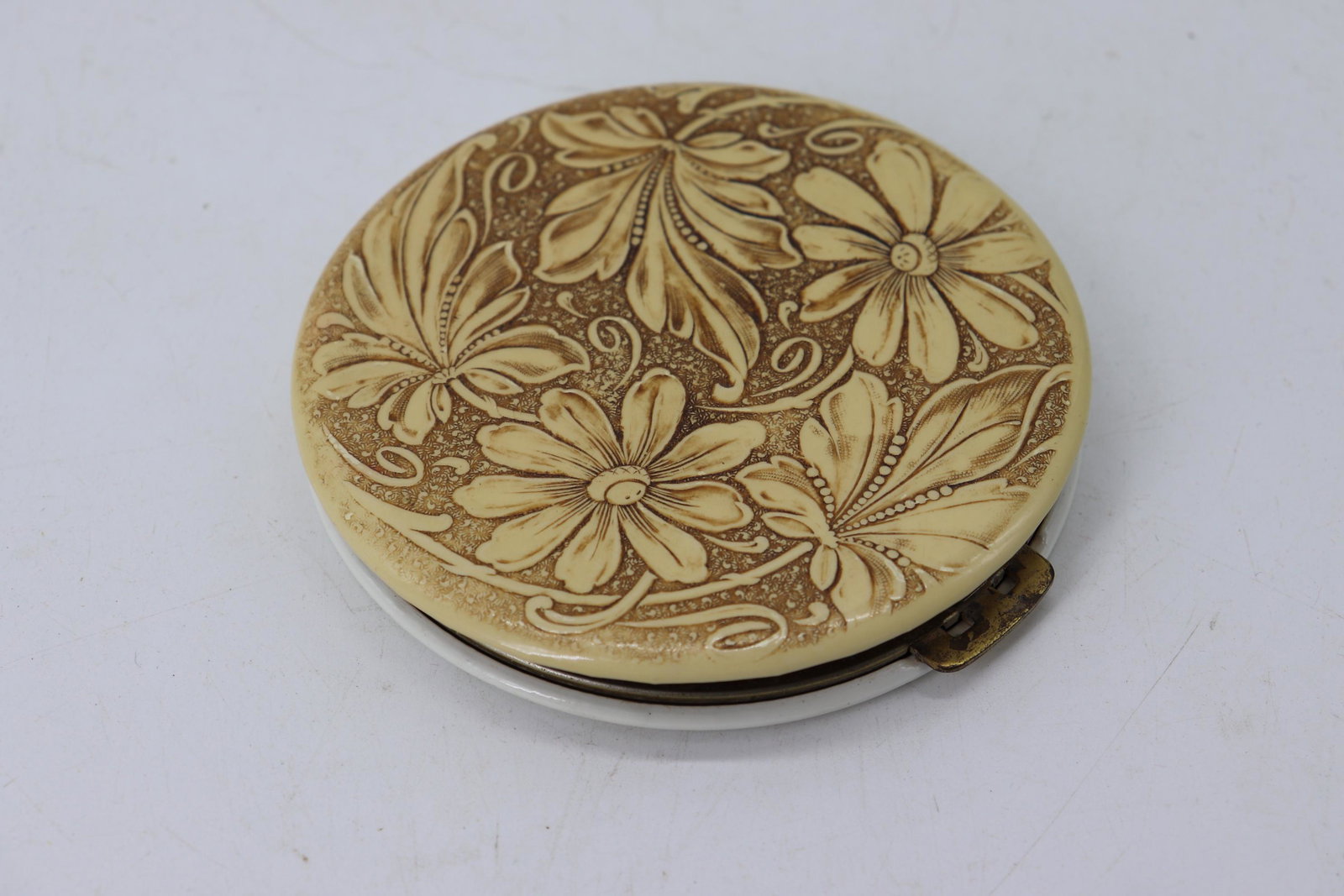 Vintage Tooled Leather Compact: floral tooled leather top, unmarked, appears to have never had powder in it, silvering loss to mirror, approx. 4 1/2 inches
