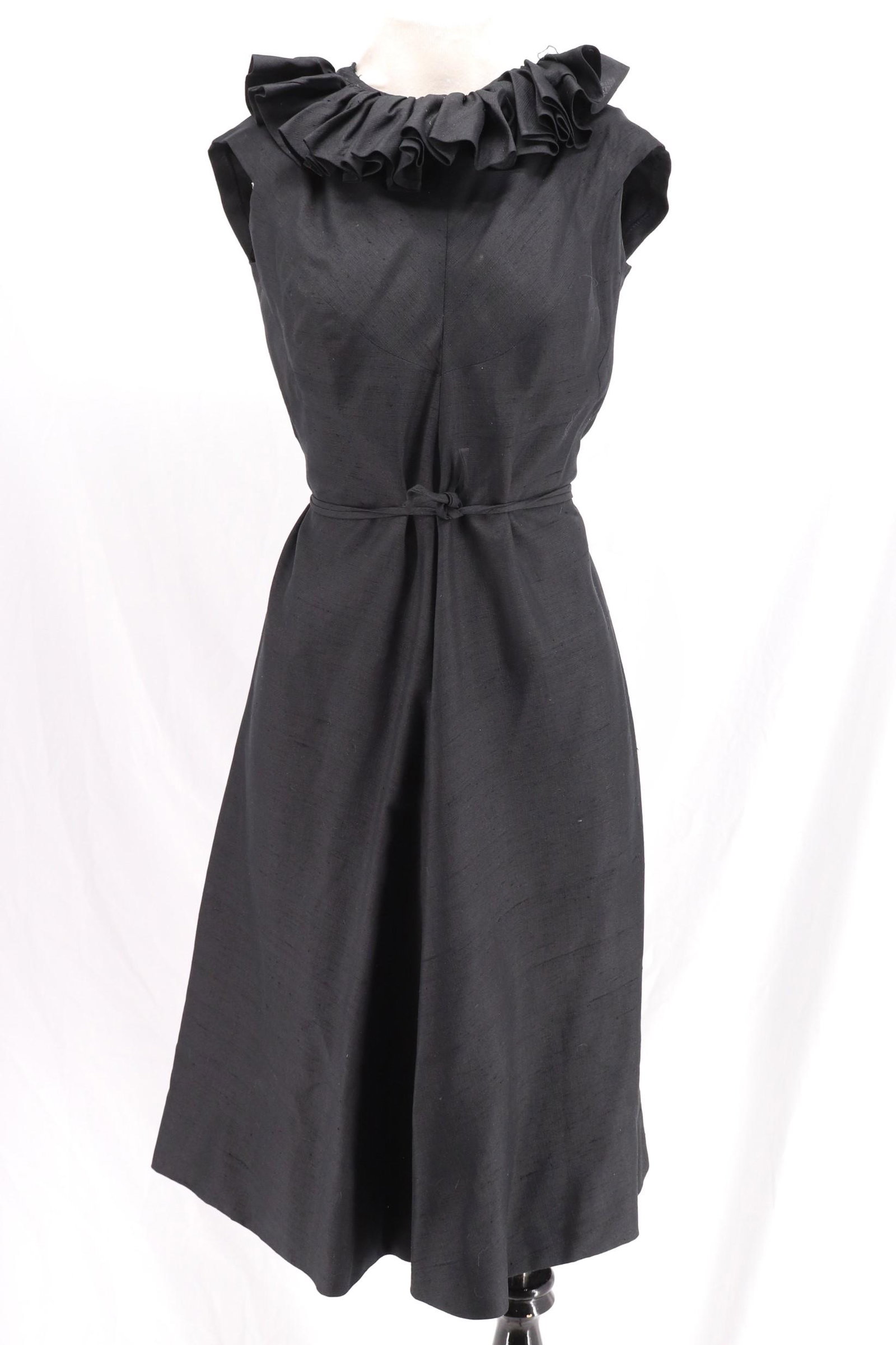 Vintage 1960's KLEIBACKER Black Cocktail Dress: sleeveless large ruffled collar, darts at bodice and slightly flare skirt, attached tie for waist, back zipper, approx. 36 bust, 28 waist, silk blend, slight damage at shoulder