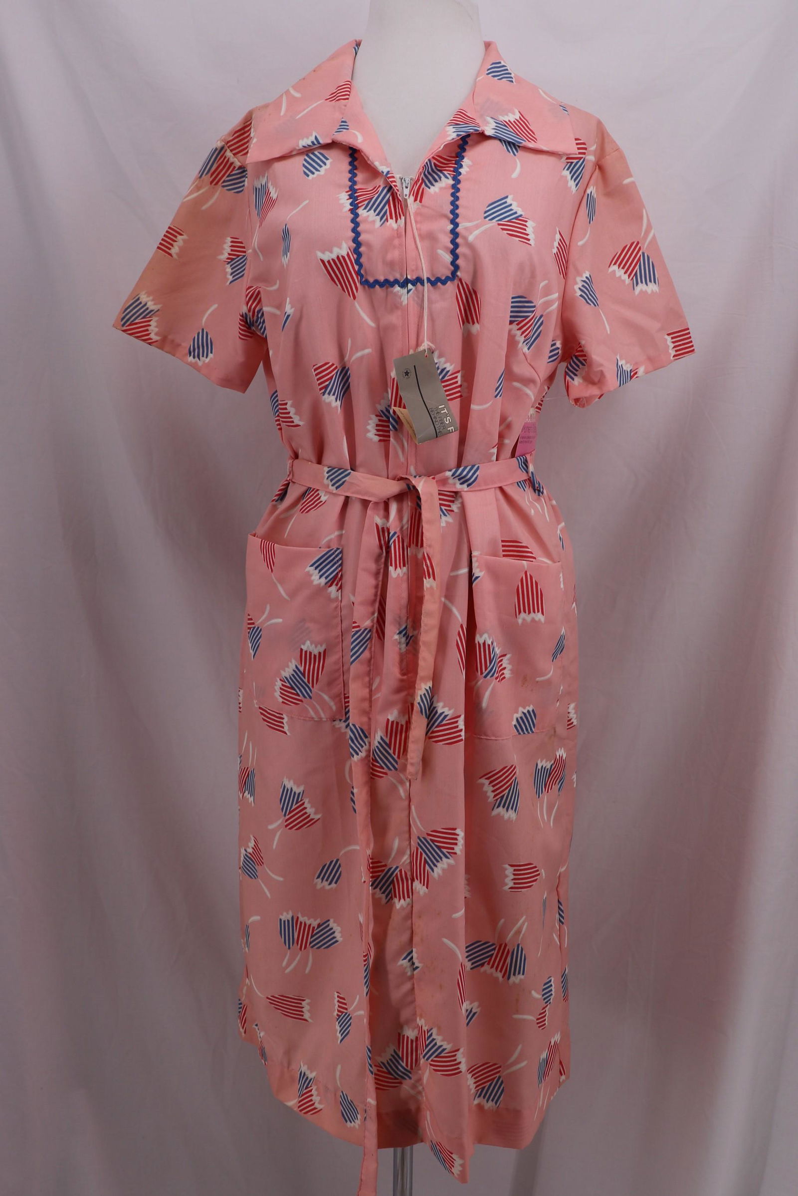 Vintage 1950's IZZY'S PLACE Cotton Blend House Coat: Zipper front, large applied front pockets, tulip pattern, matching tie belt Approx. 44 bust, 44 waist, shoulder stains and discoloration from storage, has original tags.