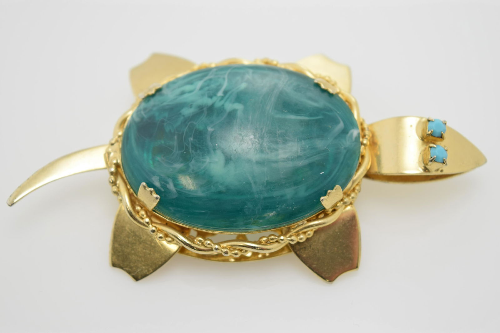 A large gold tone turtle pin with large green stone. (1 of 4)