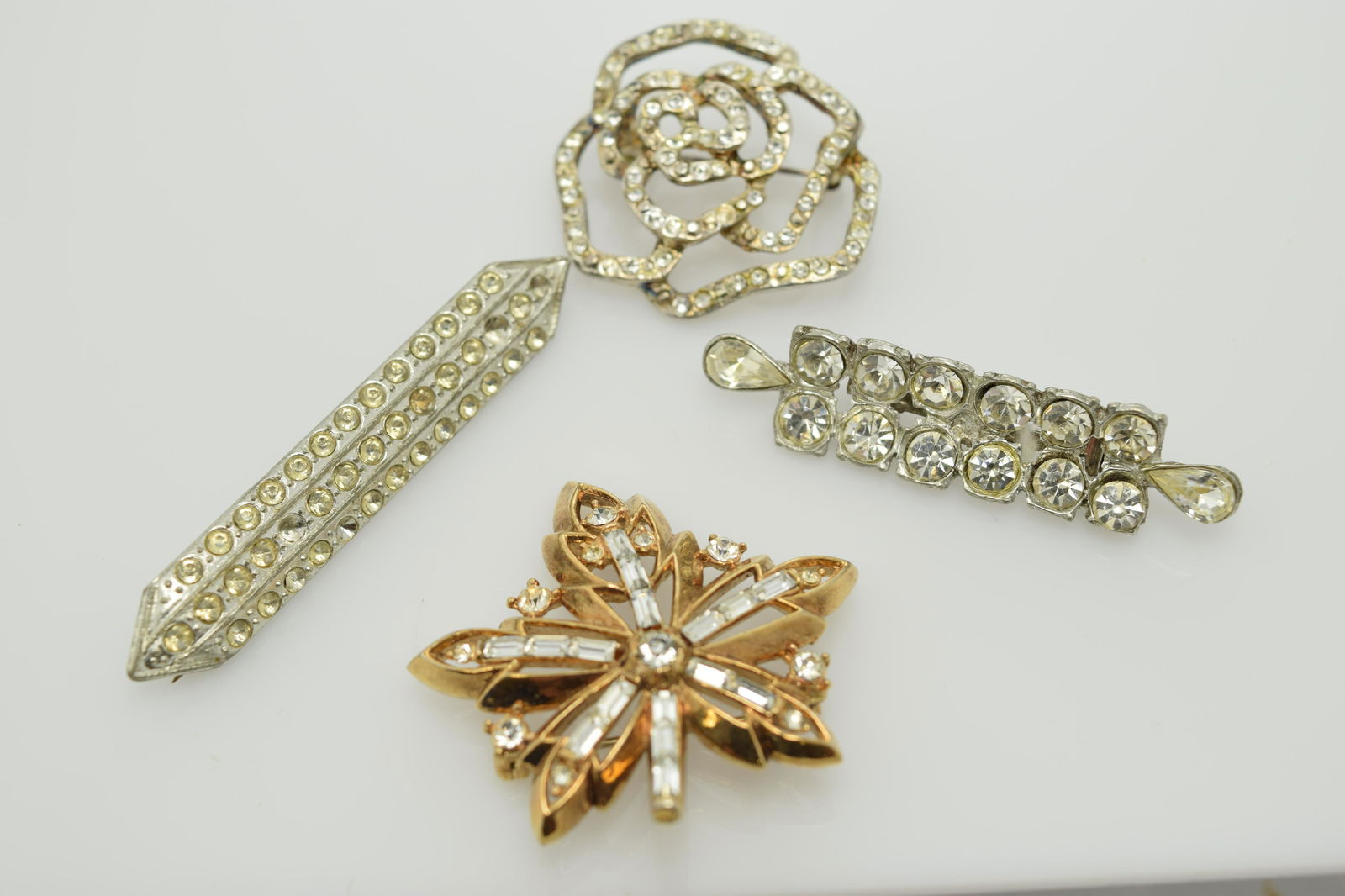 A lot of four vintage pins/brooches.: A lot consisting of 2 silver tone & clear rhinestone bar pins. 1 is marked Francine NB. There is also 2 gold tone & rhinestone pins. 1 of those is marked Cr Trifari Pat Pend. All are in pre-owned cond